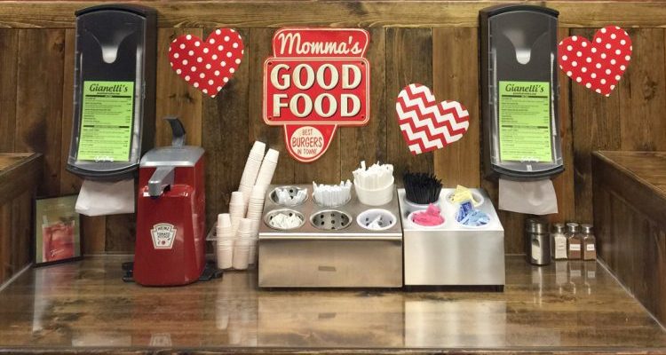 Our condiment counter, with napkin dispensers, silverware, and straws. A sign says mama's good food.